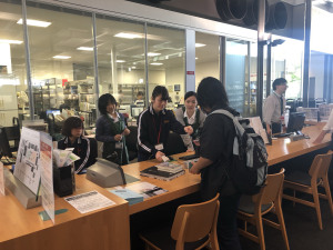 図書館でカウンター業務をする中学生たち
