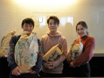 収穫した米を手にする学生たち