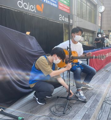 商店街でギター演奏をする学生