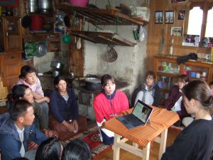 ブータンの人達にパソコンを使ってプレゼンする大学生