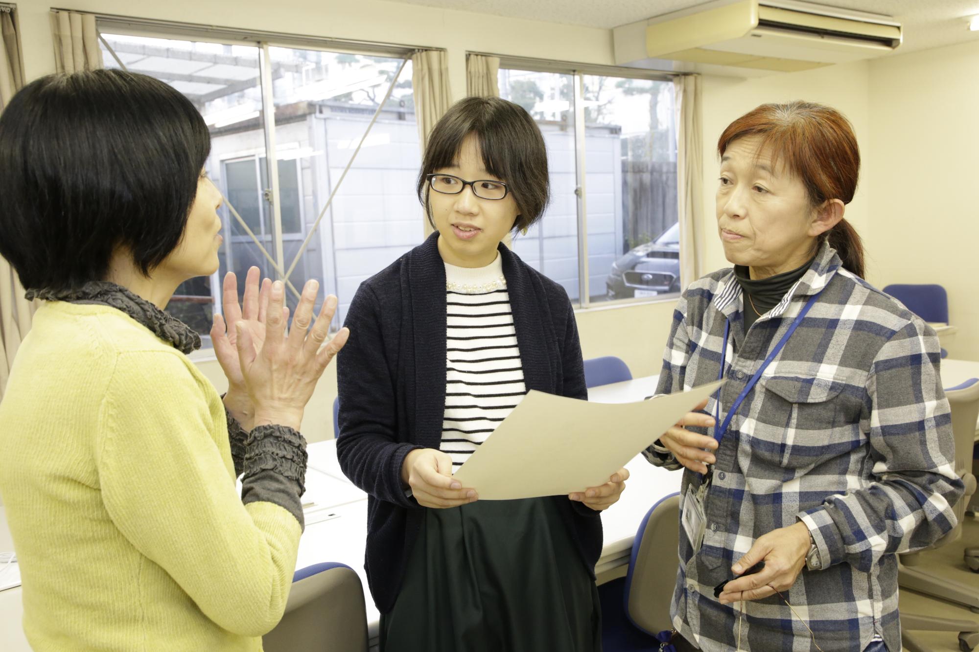 講師と学生の打ち合わせの様子を写した写真。