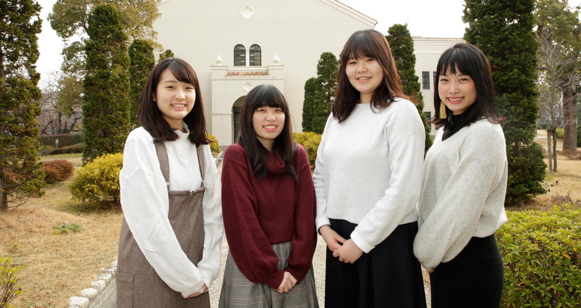 聖和短期大学の施設である山川記念館をバックに、インタビューに応じてくれた大学生4人を写した写真。